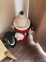 Side angle view of red and white metal fire hydrant decor, showing the white cap with 'VALVE' marking and 'Erck's Christmas 1998' inscription.
