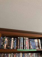 Shelf view showing multiple VHS tapes with visible movie titles including The Bodyguard, Men in Black, Robin Hood, Born in East L.A., Do the Right Thing, and others.