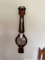 Full front view of the vintage wooden wall barometer showing entire length and details of wood finish and dial.
