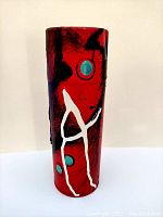 Opposite side view showing red base, black strokes, turquoise dots, and white abstract 'A' shape painted on the spray can sculpture.