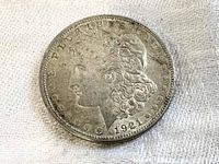 Obverse side of 1921 Morgan Silver Dollar coin featuring Liberty's profile with the date and inscriptions.