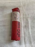 Roll of 1926 wheat pennies in red paper wrapper with handwritten '1926'