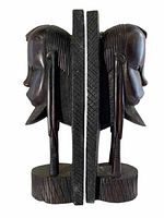 Pair of carved ebony wood African style bookends shown from side profile to highlight detailed facial carving and textured base.