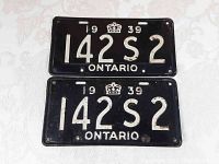 Top and front view of two black metal 1939 Ontario license plates with white embossed text '142 S 2', the year '1939' and a crown symbol. Plates show age and surface wear.