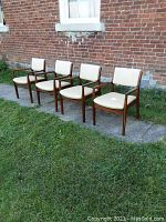 All four chairs lined up outside against brick wall showing overall lot