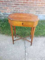 Full view of the antique Danish sewing desk with octagonal top and tapered legs.