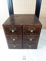 Front view of the antique oak file box showing six drawers each with metal label holders and pull handles.