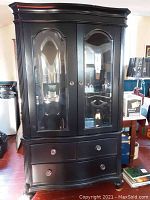 Front view of two-piece Broyhill display cabinet in black finish with glass doors, drawers, and decorative molding