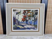 Framed oil painting with off-white wooden frame featuring fall landscape with birch trees and a path.