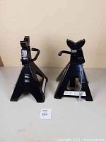 Pair of black Pro Point jack stands shown side by side, highlighting their solid triangular frame and lifting saddle.