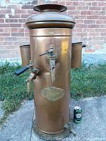 Front view of cylindrical copper boiler showing two brass spigots and side chambers