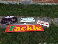 Four vintage signs laid out on grass showing Winston Art Gallery, Gone Fishing, Sorry We're Closed, and Tackle