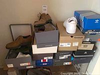 Stack of various shoe boxes with some pairs partially displayed