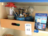 Full view of lot inside cardboard box showing 3 lanterns and 2 camp stoves with cartridges; includes box for Campingaz Lumostar C 270 lantern