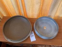 Two handmade ceramic bowls placed side by side on wooden surface, with visible rustic glaze and Japanese label