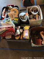 Photo showing assorted tapes, chain, twine, and hardware items in bins and boxes