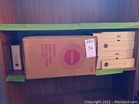 Shelf showing original box for Kodak Carousel 700 slide projector and multiple Kodak Carousel slide trays in separate boxes.