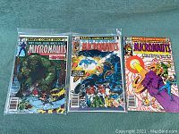 Three issues of The Micronauts comic books sealed in plastic, fanned out showing front covers.