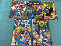 Five Marvel Tales comic books displayed on blue surface showing front covers with clear titles and artwork.