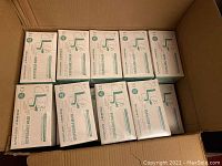 Box containing multiple sealed boxes of disposable face masks with Sanajon branding visible.