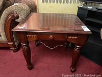 Side table shown from front angle, highlighting drawer and leg design