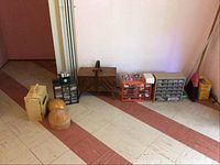 Wide angle shot of all items aligned on a floor including sewing box, plastic storage bins, and wooden hat blocks.