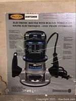 Photo of the Sears Craftsman Electronic Router packaging, showing product details and images of the router with dual handles and built-in work light.