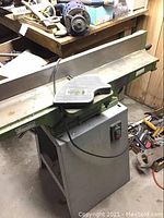 Overall view showing cast-iron tables, fence, foot pedal guard, on steel stand