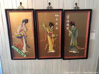 Three Asian wall art panels side by side hanging on a wood wall. Each panel features a 3D female figure in traditional dress with Asian script.