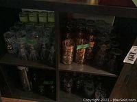 Cubed shelving unit filled with various bar glasses and stemware sets showing different styles and patterns including metallic and etched designs.