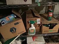 Boxes of cleaning cloths and Comet cleaning products on a metal shelving unit in basement.