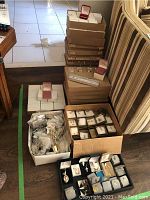 Stack of cardboard and lined jewelry boxes with loose jewelry displayed around