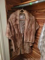 Mink fur coat and stole hanging in closet