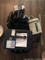 All items displayed: HP printer, Brother fax, Sony camcorder, Futura cassette player on hardwood floor.