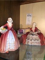 Both figurines displayed side by side on a shelf