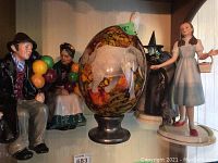 Overall view of lot including Royal Doulton elderly couple figurines, decorative elephant egg, Lenox Wizard of Oz Dorothy figurine.