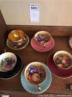 Top-down view of five teacups and saucers on wooden surface