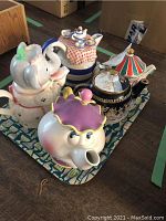 All five teapots arranged on the decorative metal tray.