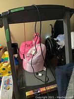 Front view of treadmill showing frame, belt surface and power cord draped over console