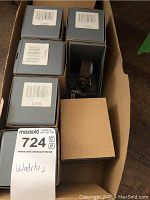 Seven Timex watch boxes arranged in a box with one watch visible in its packaging.