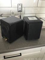 Two black Audience speakers on kitchen counter, side and front view.