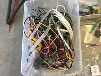Plastic bin with tangled multi-coloured audio cables and wires