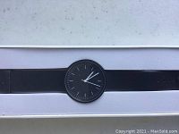 Watch laid flat in presentation box showing dial and strap