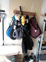 Full view of golf bag with clubs, head covers, and accompanying gear hung on hooks.