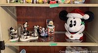 Overall shelf view showing cookie jar and multiple Mickey and Minnie Mouse figurines