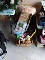 Overall view of pet ramp, basket of toys, pet bed, and food dispenser, showing arrangement of items in garage setting.