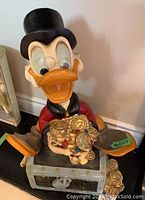 Front view of Scrooge McDuck figurine seated on treasure chest