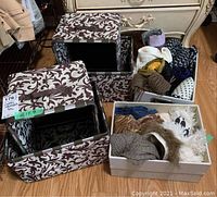 Two folding fabric storage cubes with a brown and white floral pattern, and a box of assorted scarves on the floor