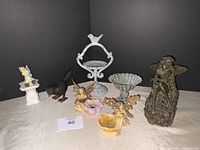 Overview photo of all decorative items including metal birdbaths, metal bird, and resin faeries, arranged on neutral background.