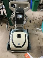 Front view of Hayward AquaVac 500 robotic pool cleaner showing overall body, wheels, suction area, and power cord coiled behind the control panel.